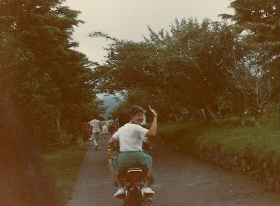 Mom wavin g'bye on a motor bike